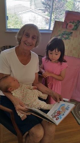 elderly woman reading a story to children