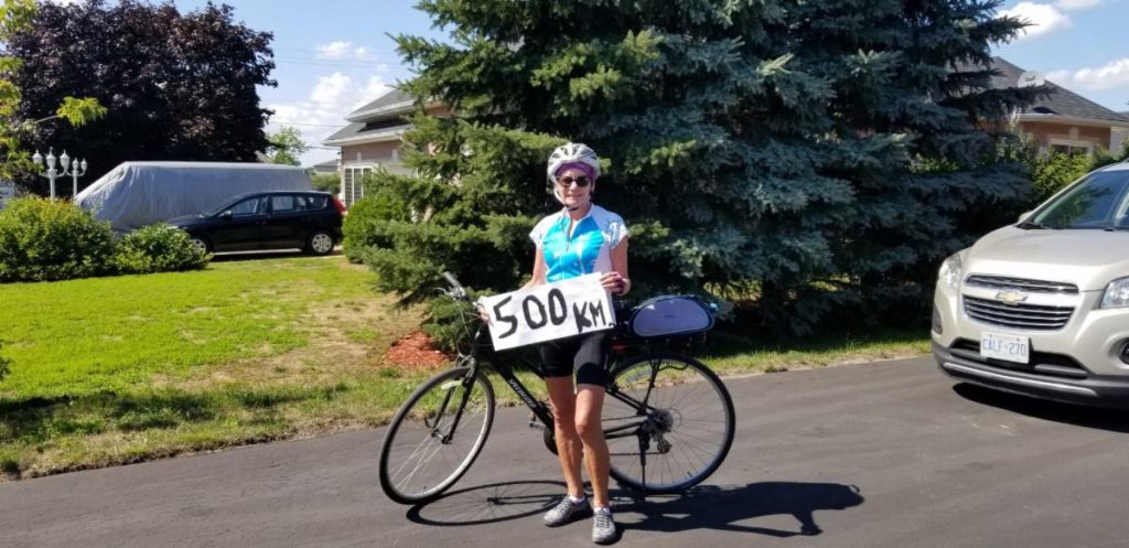 woman cyclist holding a 500km sign