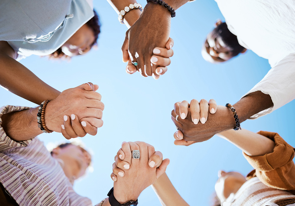 People of different races hold hands in a unity circle of support