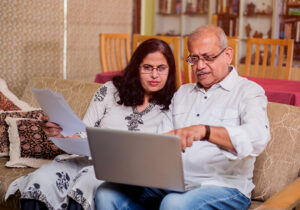 Older South Asian man and woman looking at a computer screen