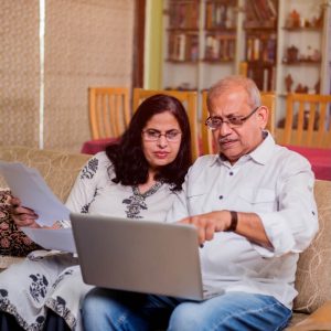 Older South Asian man and woman looking at a computer screen
