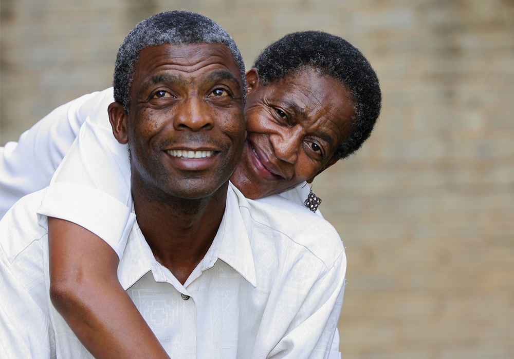A Black man and woman embracing and looking happy