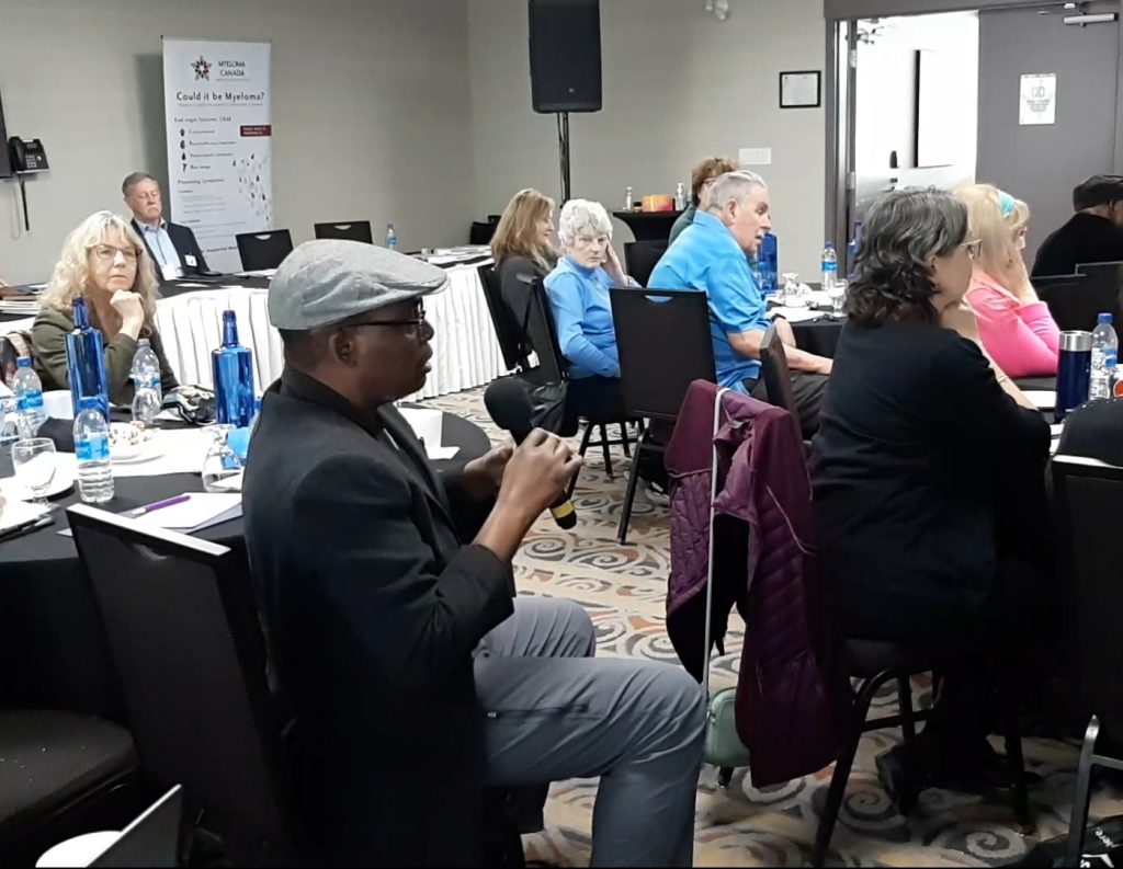 Photo of a group of people of different ages listening at a Myeloma Canada conference