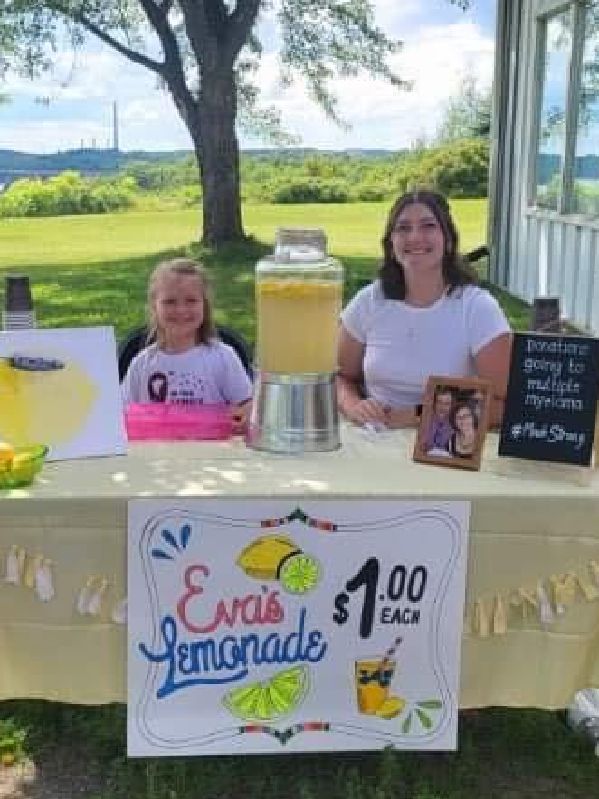 Photo d'une jeune fille accompagnée de sa tante vendant de la limonade pour un collecte de fonds pour Myélome Canada.
