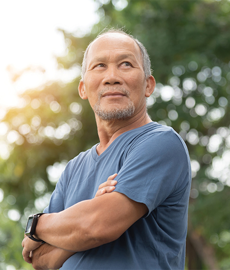 Un homme asiatique âgée regarde au loin en souriant