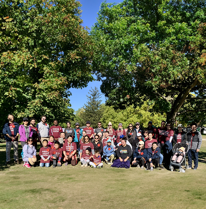 A group of people in a park before an event (SHOULD WE SAY IT IS THE MULTIPLE MYELOMA MARCH?
